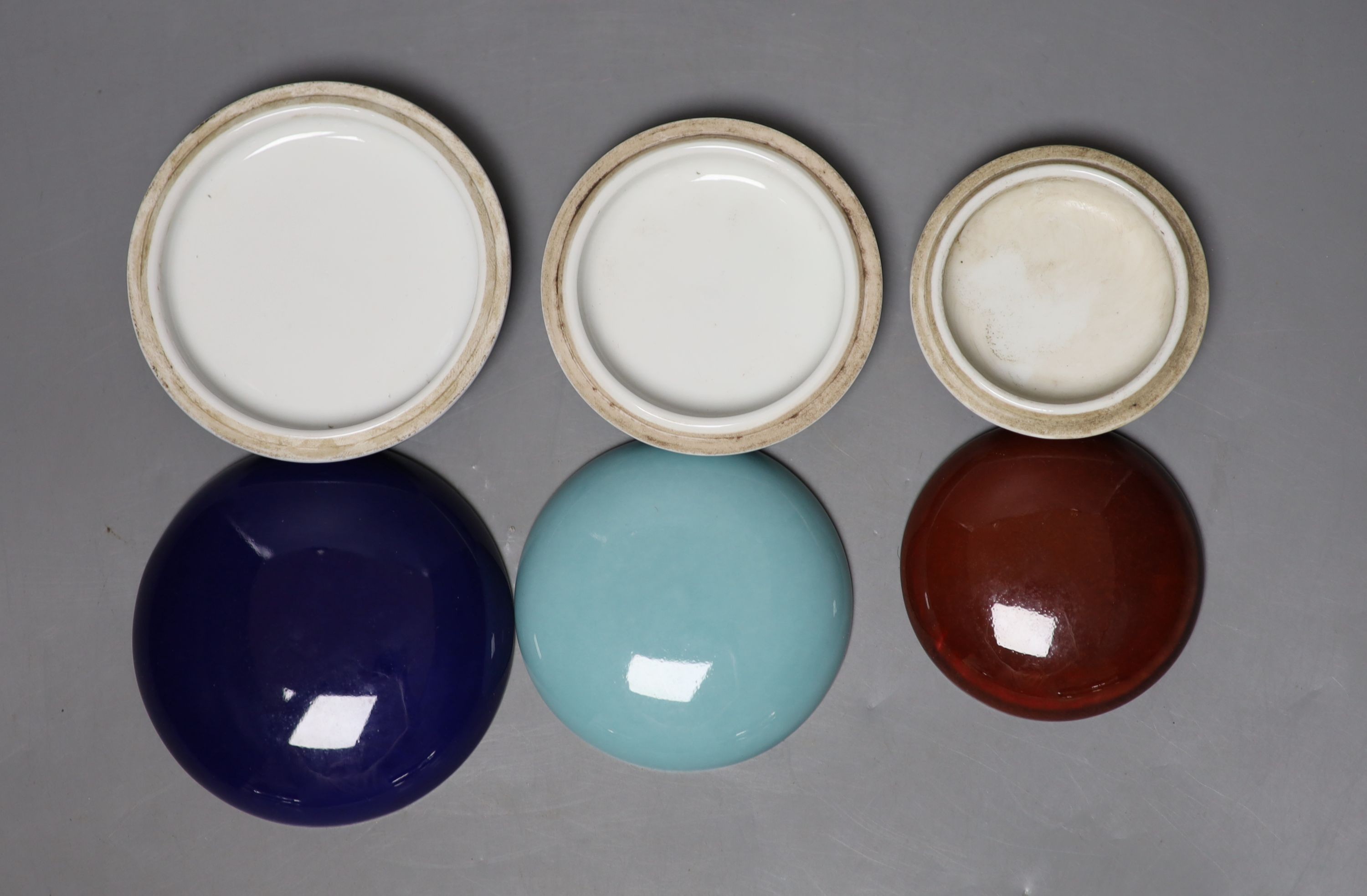 A group of three Chinese monochrome glazed seal paste boxes and covers, largest 9cm